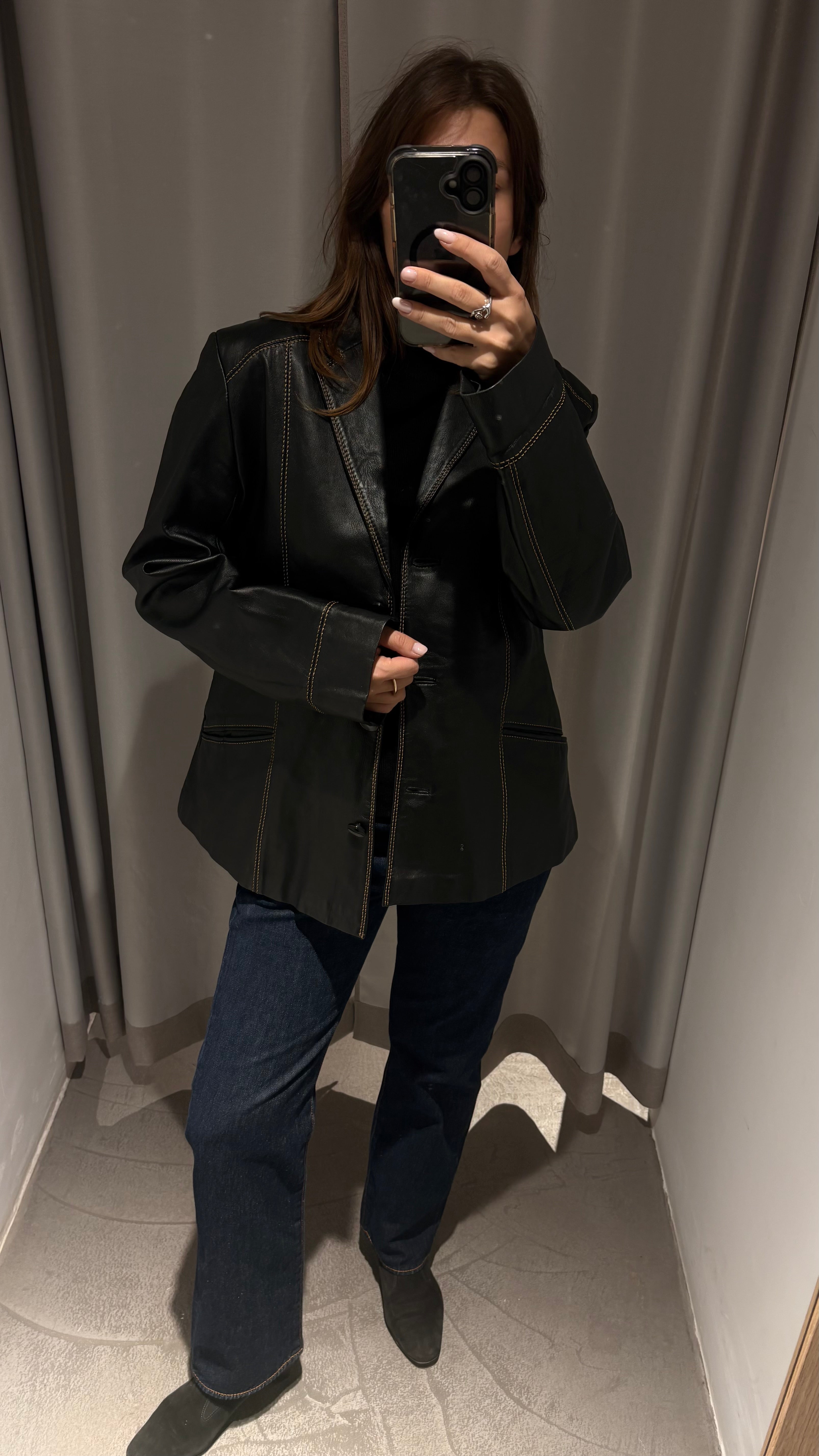 Black natural leather blazer with visible seam detailing and a cinched waist.