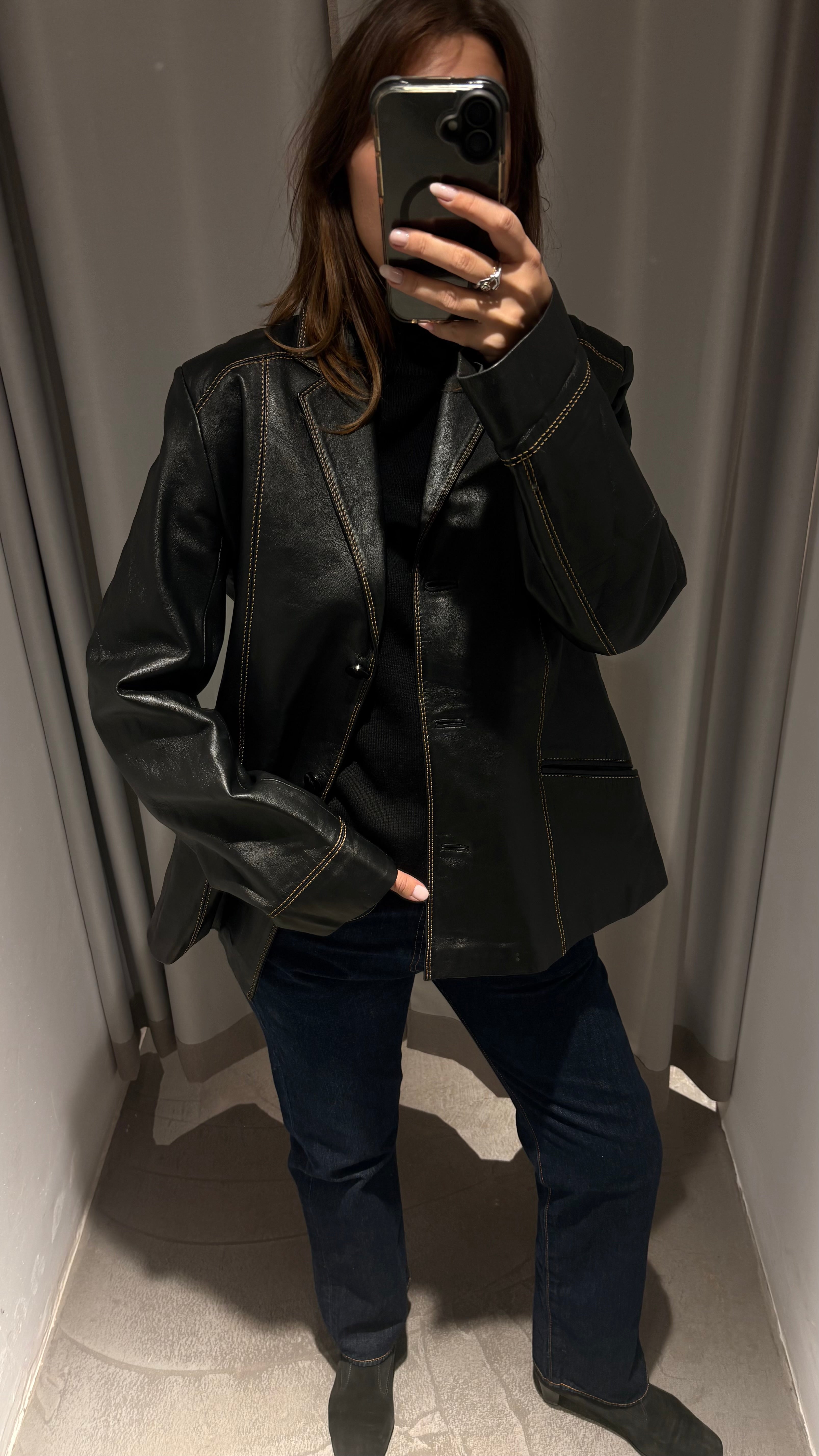 Black natural leather blazer with visible seam detailing and a cinched waist.