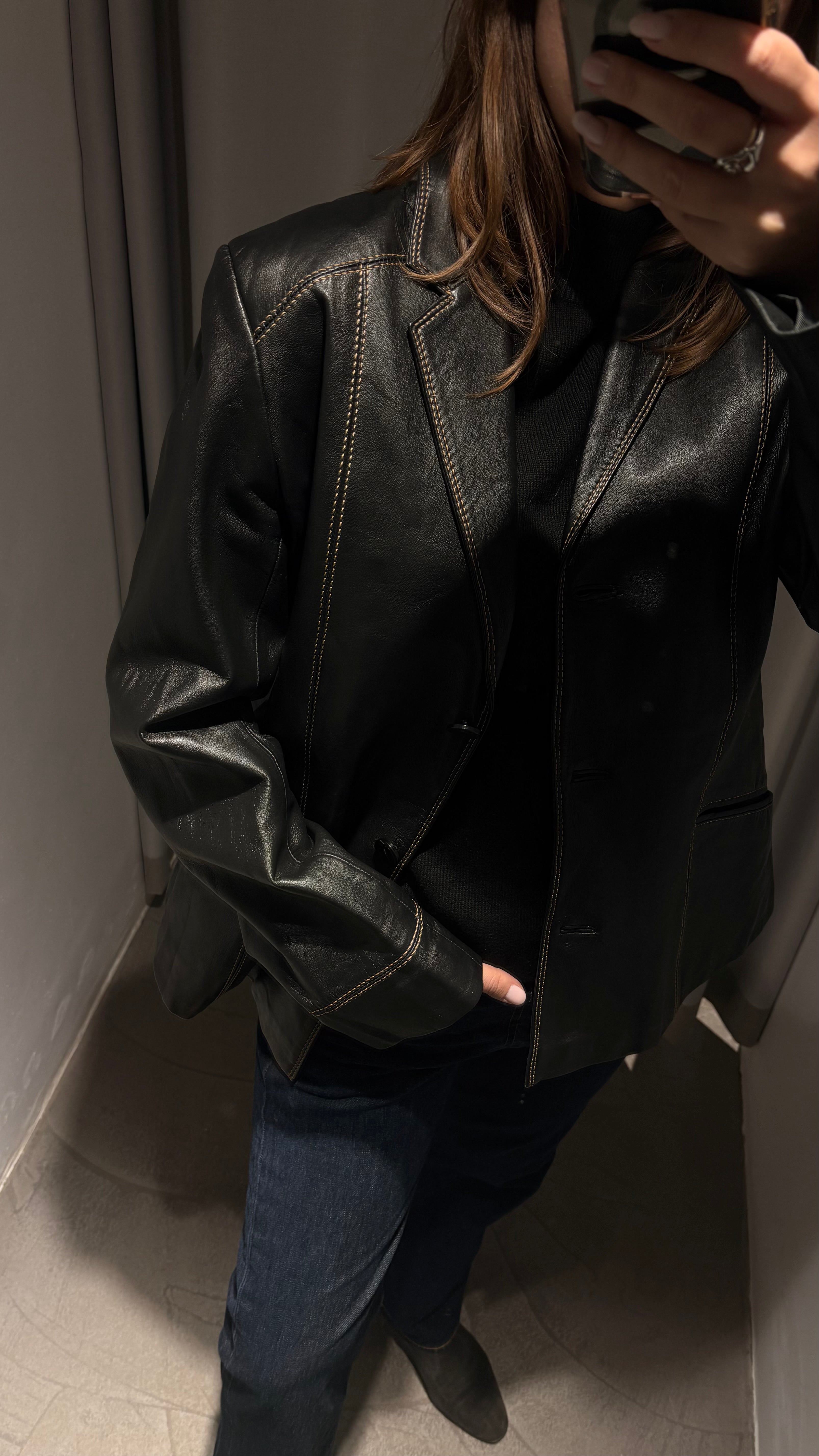 Black natural leather blazer with visible seam detailing and a cinched waist.