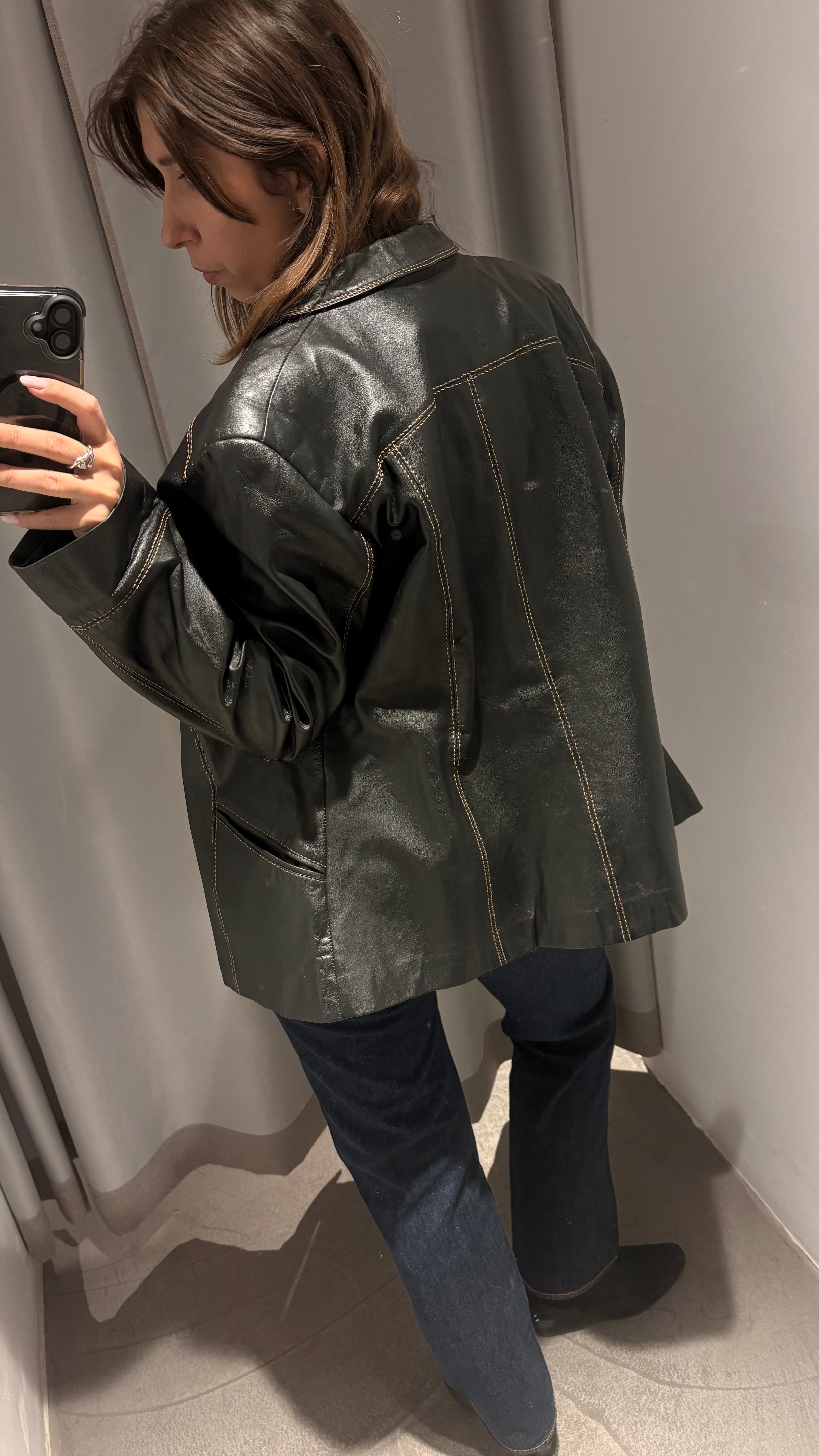 Black natural leather blazer with visible seam detailing and a cinched waist.