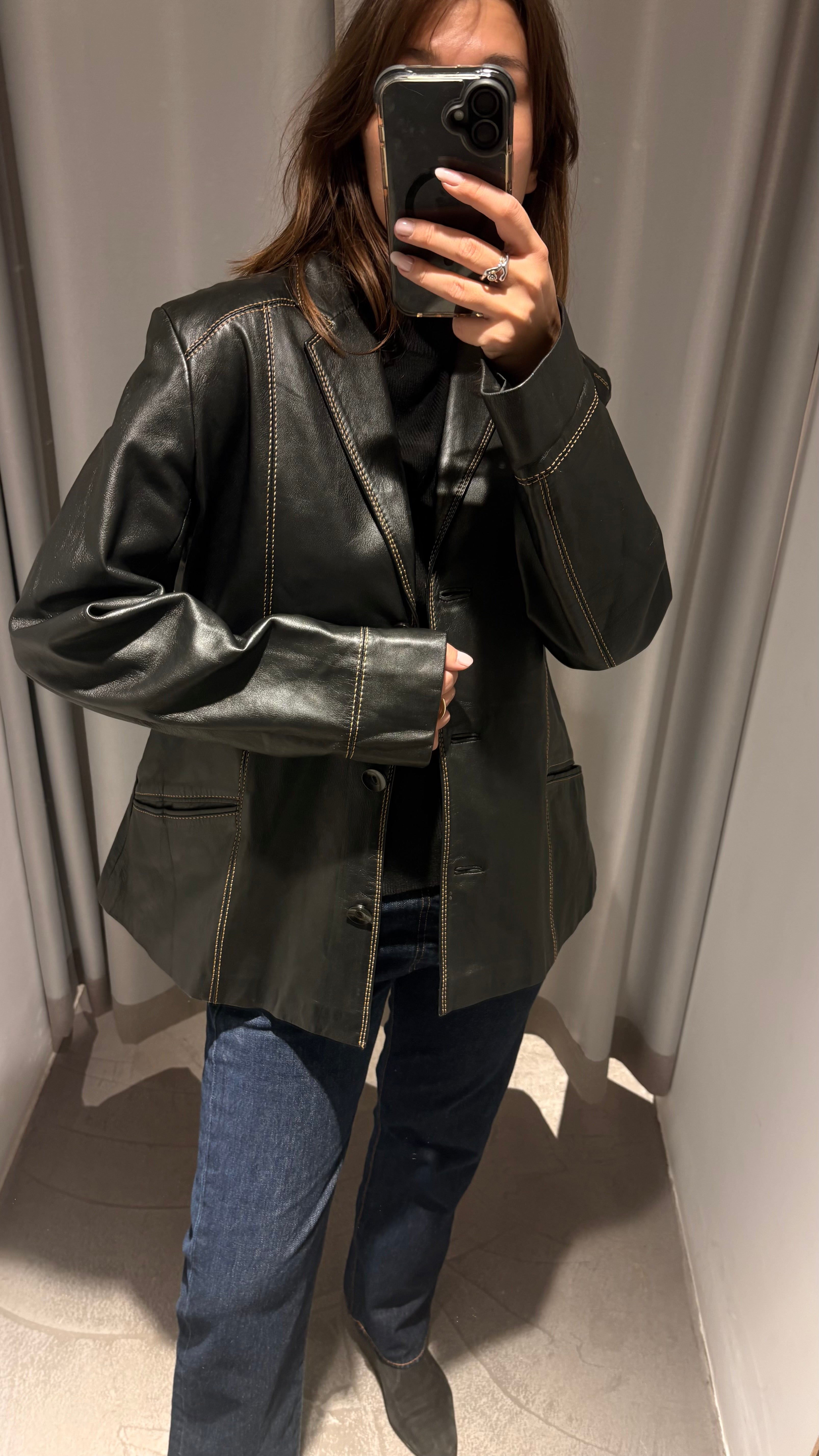 Black natural leather blazer with visible seam detailing and a cinched waist.