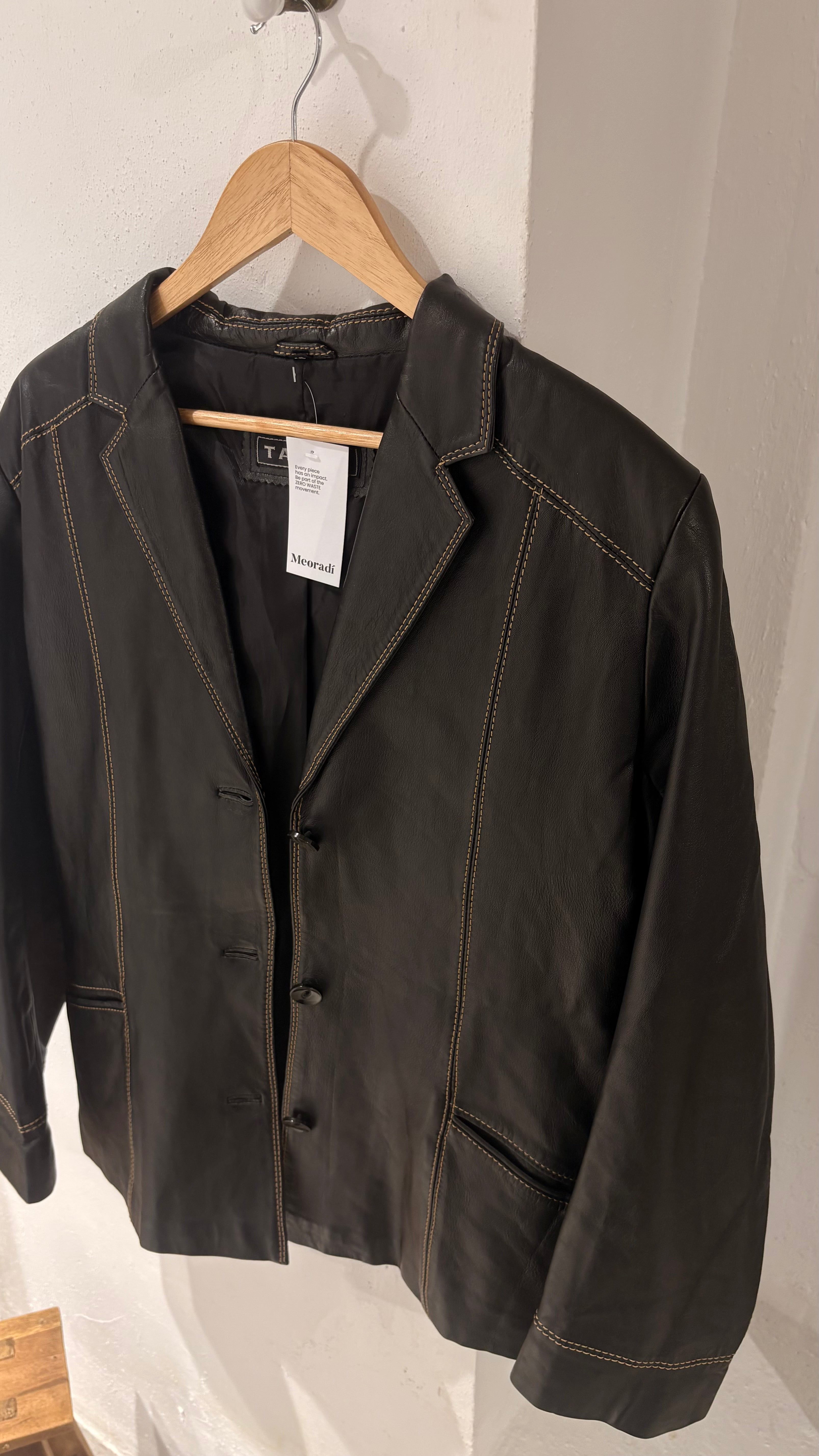 Black natural leather blazer with visible seam detailing and a cinched waist.