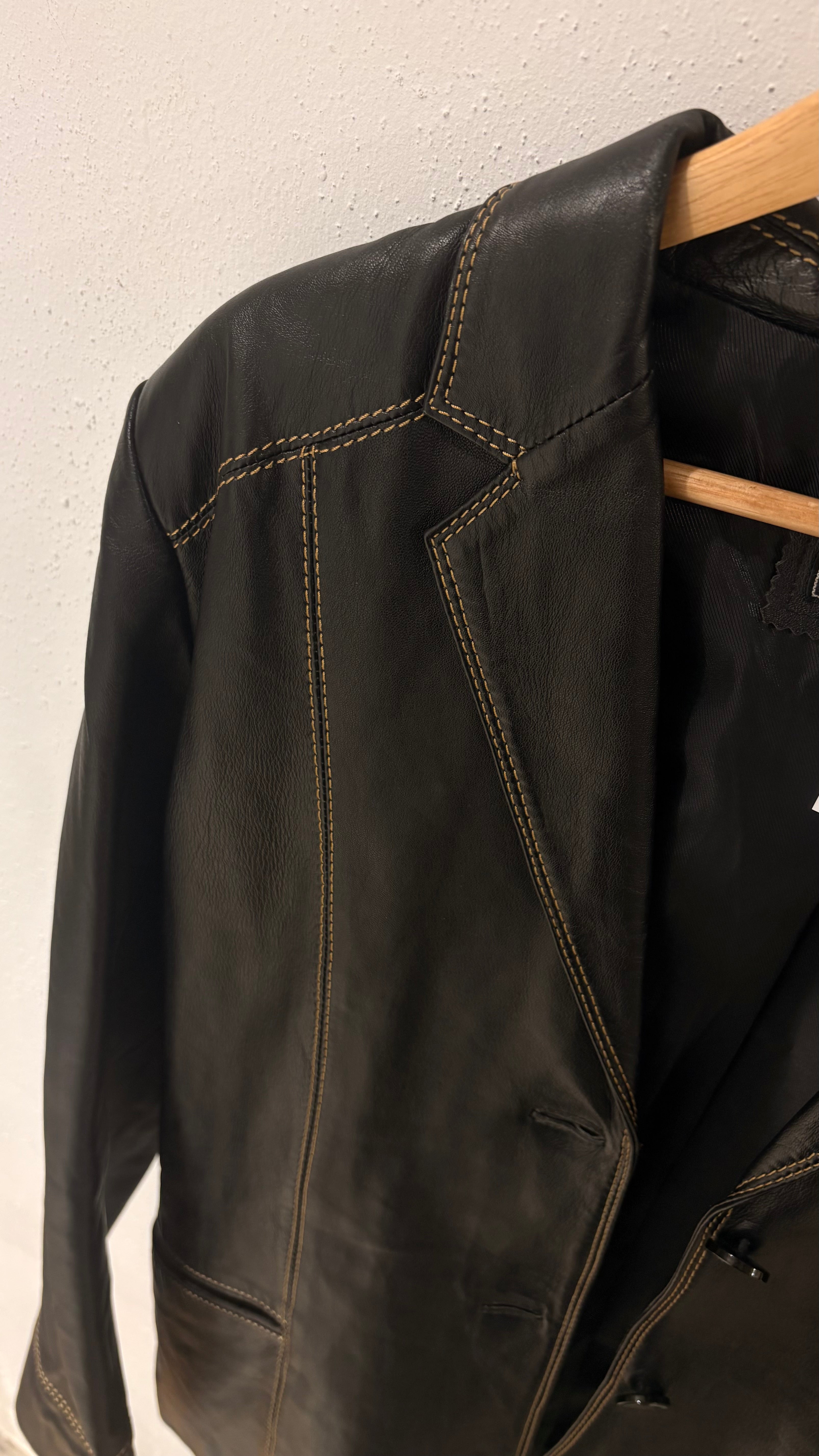 Black natural leather blazer with visible seam detailing and a cinched waist.